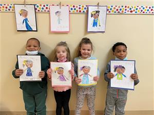 Photo of students holding portraits they've drawn of Ruby Bridges.